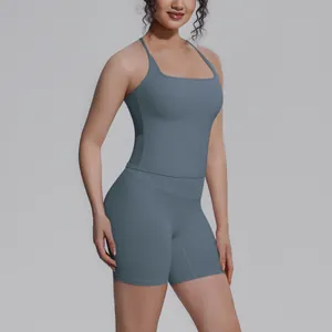 Model draagt een tweedelige blauwgrijze yoga-set bestaande uit een tanktop en korte broek