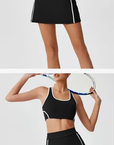Detail view of black high-waist tennis skirt and sports bra set with white trim.