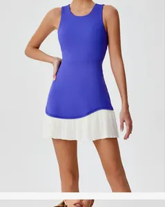 Detailweergave van een sportieve tennisjurk met blauwe top en witte geplooide rok