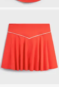 Vue détaillée d'une jupe de tennis rouge avec un motif à rayures blanches en V
