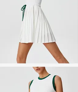Dettaglio abito da tennis bianco donna con gonna a pieghe e scollo verde.