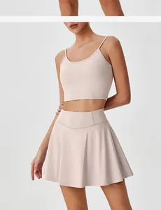 Ensemble de sport rose clair avec brassière à fines bretelles et jupe plissée taille haute.