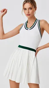 Detail of white pleated tennis dress with zipper and contrasting green trim