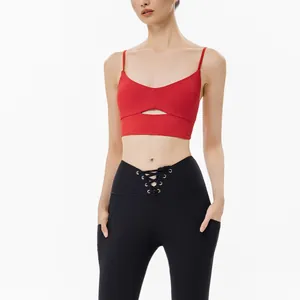 Reggiseno sportivo yoga rosso professionale con leggings neri stringati su sfondo bianco