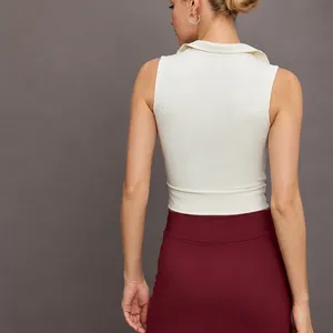 Mouwloze witte polo sporttop gecombineerd met een golvende bordeauxrode tennisrok