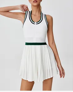Close-up of white sports tennis dress with green contrast waist and pleated skirt