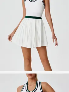 Detail of breathable white zip-up tennis dress with green waistband and pleated skirt