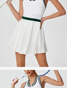Close-up of white pleated tennis dress with green stripe accents and front zipper.