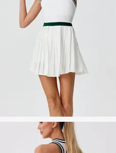Detailed view of white pleated tennis skirt with contrast green waistband stripe