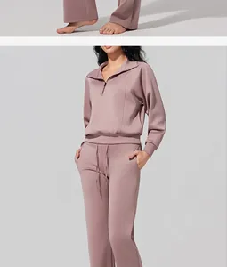 Full-body view of women's dusty rose half-zip sweatshirt and flared yoga pants set