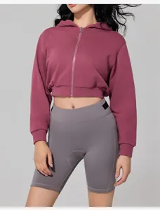 Detailed view of women's cropped maroon zip-up hoodie and grey high-waist biker shorts