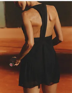 Detailed view of women's black mesh tennis dress featuring an open back and breathable fabric.