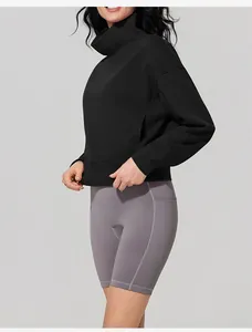 Detailed view of a black high-collar sweatshirt paired with grey cycling shorts.