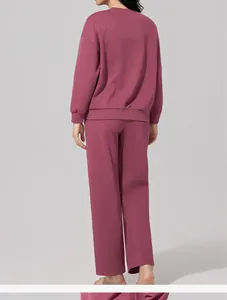 Vista trasera de un conjunto de sudadera de manga larga y pantalones para mujer en malva