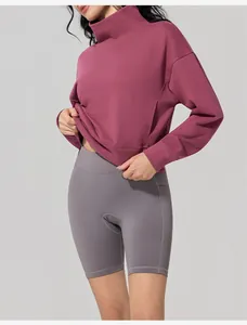 Detailed view of women's mauve turtleneck sweatshirt and grey biker shorts for outdoor sports