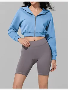 Women's blue cropped zip-up hoodie paired with grey high-waisted cycling shorts