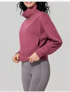 Side view of a woman wearing a mauve stand collar sweatshirt and grey athletic leggings