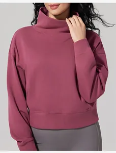 Close-up view of a minimalist women's high-neck pink sweatshirt featuring soft fleece fabric