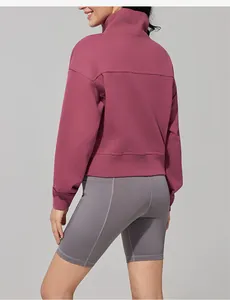Back view detail of a women's stand collar sweatshirt paired with grey cycling shorts