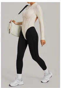 Vue latérale d'un body de yoga bicolore à manches longues et dos nu en crème et noir