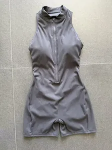Primo piano del dettaglio della mezza zip frontale di una tutina da yoga grigia