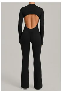 Back view of a black long-sleeve yoga jumpsuit with an open back and flared legs.