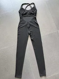 Achteraanzicht van een zwarte yoga jumpsuit met kruisbandjes en een open rug ontwerp.