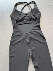 Gedetailleerd achteraanzicht van een zwarte yoga bodysuit met V-vormige taille