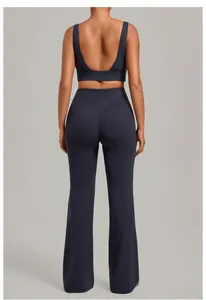 Back view of navy blue sports bra and flared yoga pants set with V-shaped waistband.