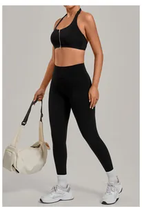 Woman wearing black high-waisted yoga leggings and front-zipper sports bra with gym bag