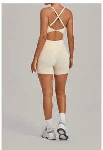 Back view of a beige one-piece yoga bodysuit with cross-straps and adjustable buckle.