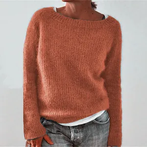 Close-up detail of soft burnt orange round neck knit sweater showing wool texture