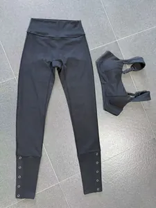 Detailed view of black brushed yoga set featuring adjustable straps and snap-button leggings