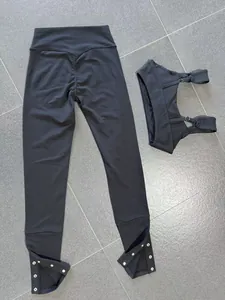 Black brushed yoga set featuring adjustable strap sports bra and button-detail leggings.