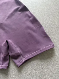 Close-up of purple yoga bodysuit showing flatlock stitching and soft fabric texture