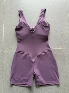 Detail van een paars mouwloos U-hals yoga bodysuit met V-vormig taille stiksel detail