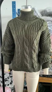 Detailed view of an olive green chunky cable knit turtleneck sweater on a mannequin