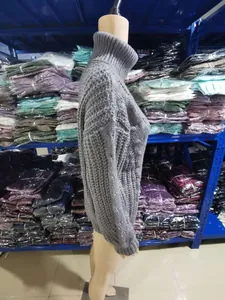 Side view detail of a grey high neck chunky knit sweater on a retail display mannequin