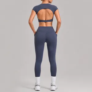 Women's two-piece yoga workout set with backless crop top and pocket leggings