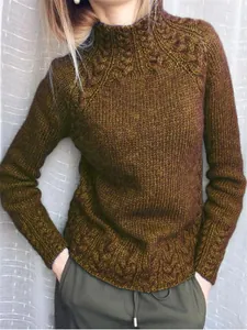Gros plan sur la texture torsadée complexe et le col montant de ce pull vert olive
