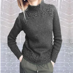 Gros plan détaillé d'un pull gris foncé à col montant avec de beaux motifs torsadés