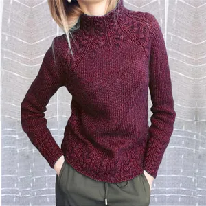 Vue détaillée d'un pull en tricot bordeaux avec des motifs torsadés au col et à l'ourlet bas