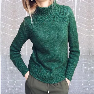 Gros plan d'un pull vert en maille torsadée montrant les détails du motif tissé