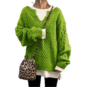 Detailansicht des grünen Zopfstrickpullovers mit weißem Hemd im Schichtlook.