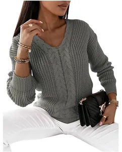 Detail of a women's grey V-neck cable knit sweater with elegant gold jewelry accents.