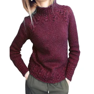 Gros plan détaillé du motif torsadé complexe sur un pull à col montant couleur bordeaux