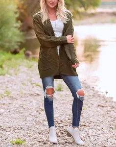 Detalle del cárdigan de punto trenzado verde militar para mujer en un entorno natural