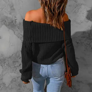 Back view detail of an off-the-shoulder loose black knit sweater with ribbed texture.