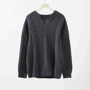 Detailansicht des eingekerbten Rundhalsausschnitts und der Zopfstrickstruktur des Pullovers