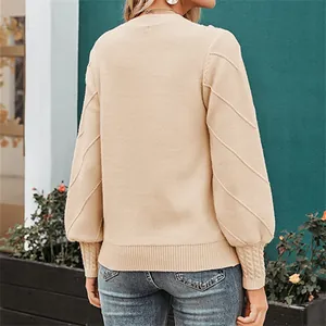 Detailed back view of an elegant beige knit sweater featuring puff sleeves and textures.